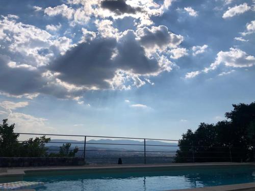 una piscina con un cielo nublado en el fondo en Borgo dei Conti Campello, en Campello sul Clitunno