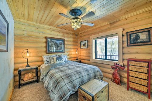 1 dormitorio con 1 cama y ventilador de techo en Charming Bedford Cabin with Private Hot Tub!, en Thayne