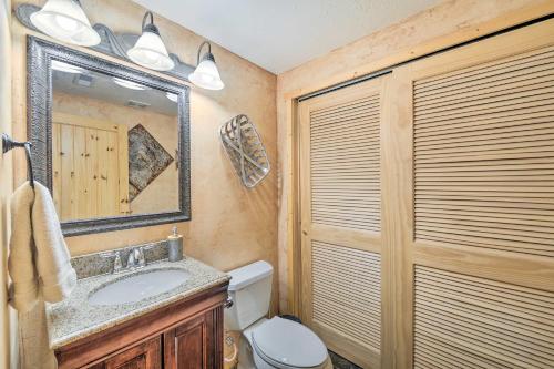 a bathroom with a sink and a toilet and a mirror at Charming Bedford Cabin with Private Hot Tub! in Thayne