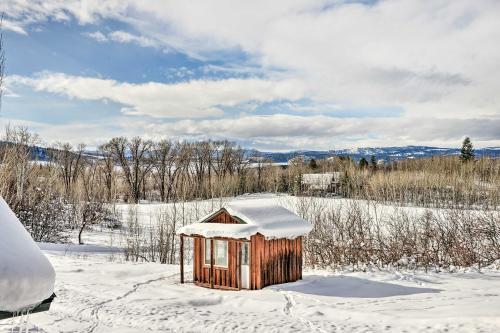 a smallshed in a snowy field with snow at Charming Bedford Cabin with Private Hot Tub! in Thayne