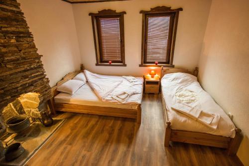two twin beds in a room with two windows at Guest House Panorama in Gela