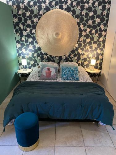 a bedroom with a bed with a blue comforter at Le Loft PATIO, au coeur du village in Saint-Rémy-de-Provence