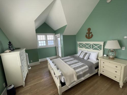 um quarto com uma cama e uma cómoda branca em Nubble Beach House- York Beach Oceanfront w/ Amazing Views em York