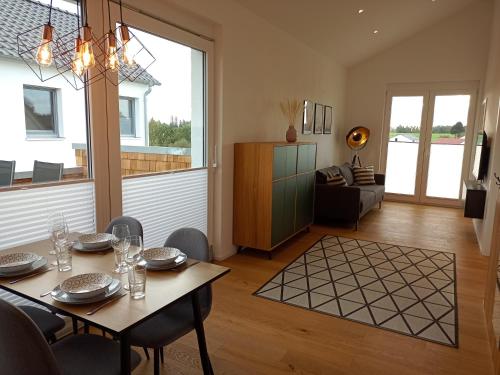 a dining room with a table and a living room at Ferienwohnung Mundry 