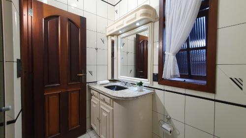 W łazience znajduje się umywalka i lustro. w obiekcie Pousada dos Arcos w mieście Ascurra