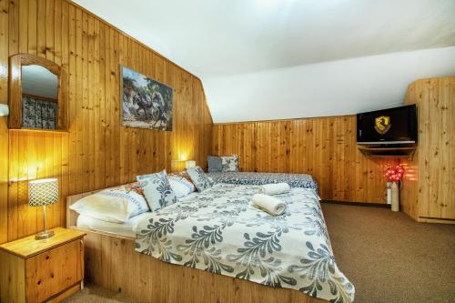 um quarto com uma cama grande e paredes de madeira em Penzión Ciriak em Ždiar