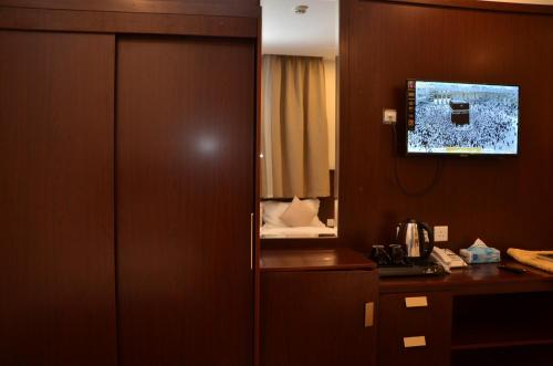 a hotel room with a mirror and a room with a bed at فندق قرطبة العزيزية in Makkah