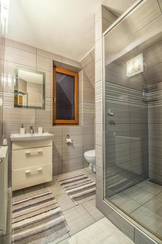 a bathroom with a shower and a sink and a toilet at Penzión Ciriak in Ždiar