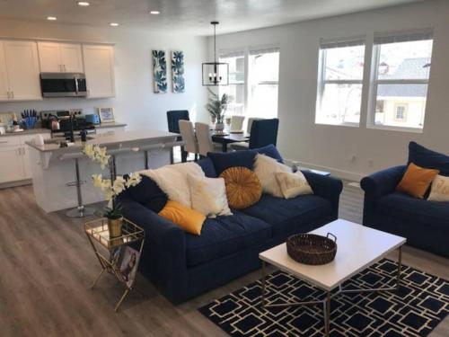 ein Wohnzimmer mit einem blauen Sofa und einer Küche in der Unterkunft Draper Luxury Townhouse in Draper