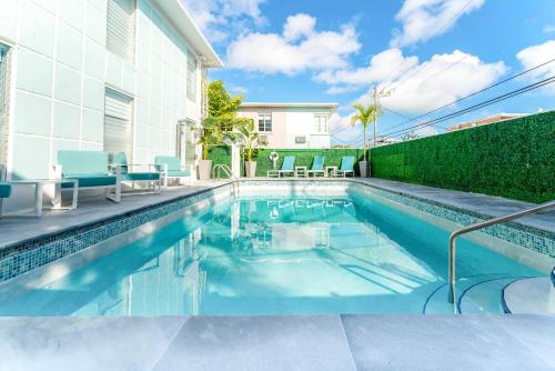 a swimming pool with chairs and a house at PRAIA Hotel Boutique & Apartments Miami Beach in Miami Beach