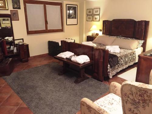 a bedroom with a bed and a table and chairs at LA CORTE DEL MULINO 1725 in San Salvatore Telesino