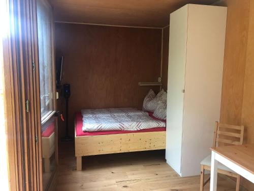 ein kleines Schlafzimmer mit einem Bett im Schrank in der Unterkunft Tiny Häuschen in Ossiach