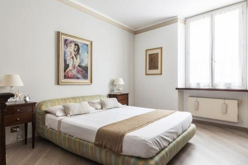 a white bedroom with a large bed and a window at Caprera Flexyrent NO air conditioning - Seafront in Santa Margherita Ligure