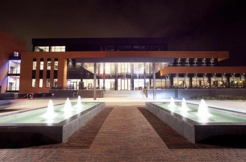 a building with a fountain in front of it at night at Van Der Valk Hotel Almere in Almere