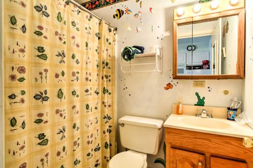 a bathroom with a toilet and a sink and a shower curtain at Balcony and Ocean Views Central Ocean City Condo in Ocean City
