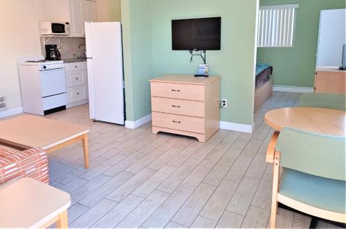 a living room with a refrigerator and a table at Johns Pass Beach Motel in St Pete Beach