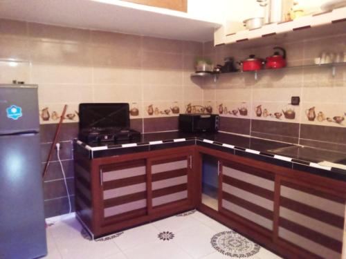 a kitchen with a stove and a refrigerator at RESIDENCE ANAS in Dakhla