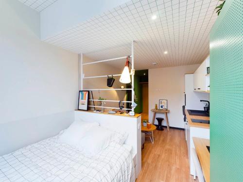 Schlafzimmer mit einem weißen Bett und einem Schreibtisch in der Unterkunft Résidence Kley Angers in Angers