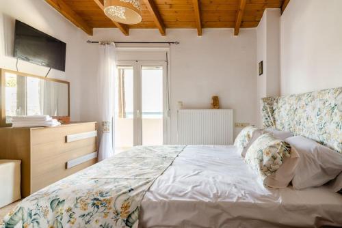 ein Schlafzimmer mit einem Bett, einer Kommode und einem Fenster in der Unterkunft Sea Aura Crete, family seaside house in Agia Pelagia in Agia Pelagia