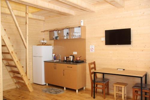 eine Küche mit einem kleinen Tisch und einem Kühlschrank in der Unterkunft Chalet Rivier • შალე რივიერ in K'eda