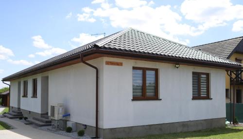 a white house with a black roof at Bingo in Powidz