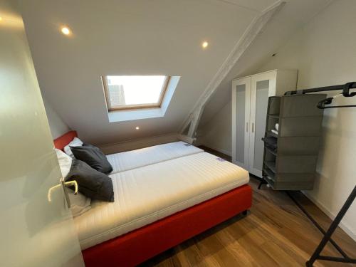 a small bedroom with a bed and a window at TopSleep Apartment 26-3 in Arnhem