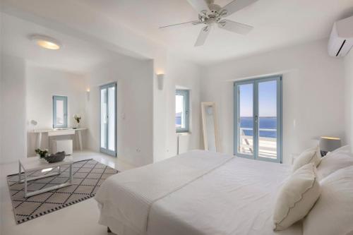 1 dormitorio blanco con 1 cama grande y ventanas en Thea Villas Paros, Villa Turquoise, private pool, en Kampos