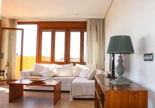 Apartamento Alcocebre Beach Resort في الكوسيبري: غرفة معيشة مع أريكة بيضاء وطاولة