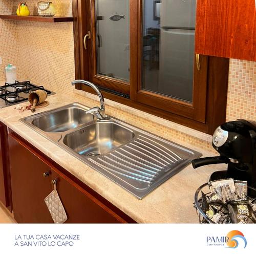 a stainless steel sink in a kitchen next to a stove at Pamir Casa Vacanze Villetta in San Vito lo Capo