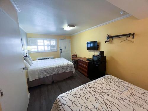 a hotel room with two beds and a flat screen tv at Motel 6 San Francisco CA Fisherman"s Wharf in San Francisco