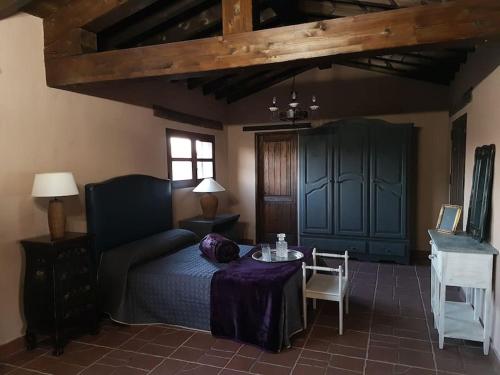 um quarto com uma cama, uma mesa e um piano em Casa Volcán em La Oliva