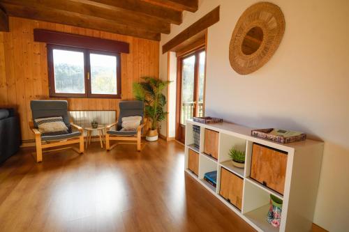 a living room with two chairs and a table at Artesoro Baserria in San Pedro de Galdames