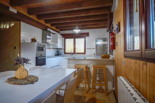 a kitchen with a white counter and wooden ceilings at Artesoro Baserria in San Pedro de Galdames