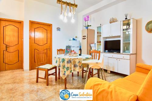 una cucina e un soggiorno con tavolo e sedie di CasaSalentina a Santa Maria al Bagno