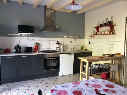uma cozinha com um fogão e uma mesa em La Ferme Fortin em Gensac-la-Pallue