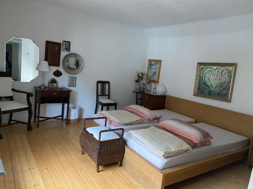 1 dormitorio con 2 camas, mesa y silla en Casa Siepelunga, en Villmar