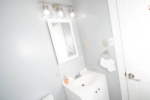 a white bathroom with a sink and a mirror at Midtown Serenity in Little Rock in Little Rock