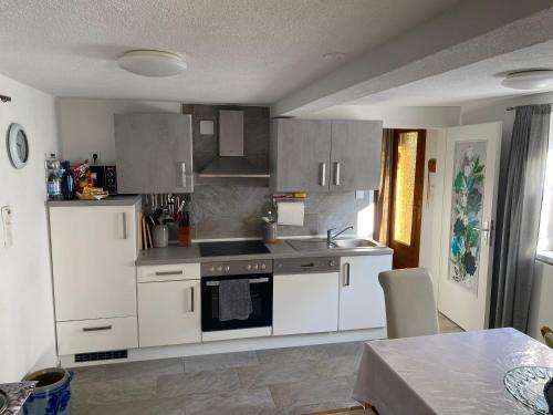 a kitchen with white cabinets and a stove top oven at Casa Siepelunga in Villmar