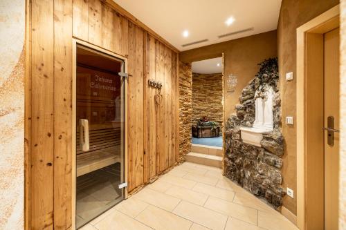 a hallway with wooden walls and a stone wall at Hotel Breitlehenalm in Obertauern