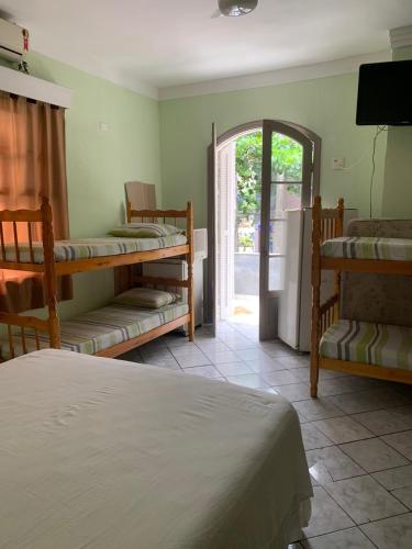 a room with bunk beds and an open door at Pousada Guarujá in Guarujá