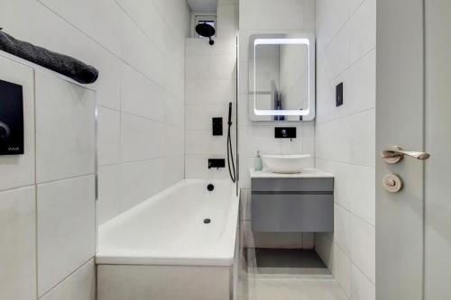 a white bathroom with a sink and a bath tub at Brand New Luxury 2-Bed Apartment in London in London