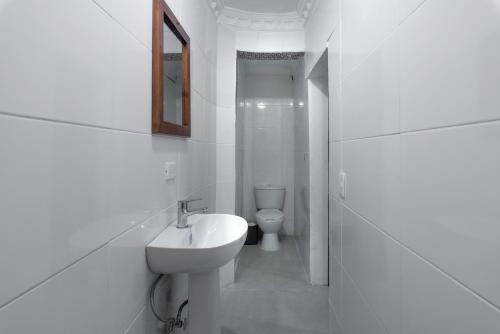a white bathroom with a sink and a toilet at Tropical Island Aparthotel, Budget Rooms & Family Apartment Rentals in Santo Domingo