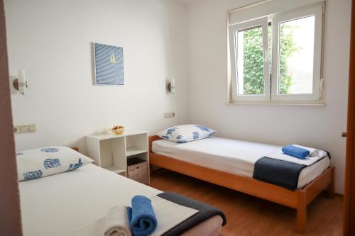 - une chambre avec 2 lits et une fenêtre dans l'établissement Apartment Valentina - private pool,200m from beach, à Omiš