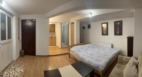 a bedroom with a bed and a living room at Apartman MT in Kiseljak