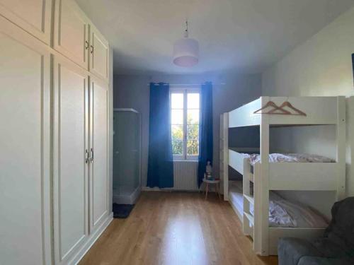 1 Schlafzimmer mit 2 Etagenbetten und einem Fenster in der Unterkunft Maison à Arcachon avec piscine hors-sol in Arcachon