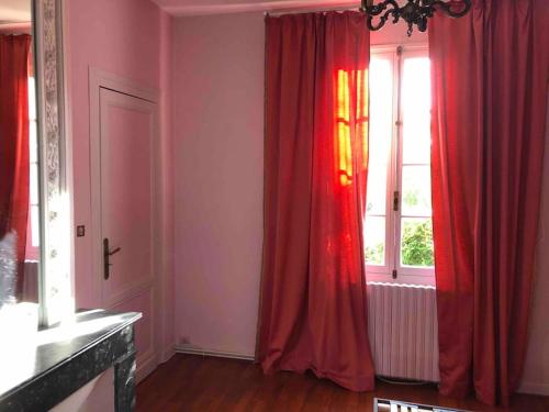 una camera con tende rosse e una finestra di Maison à Arcachon avec piscine hors-sol ad Arcachon