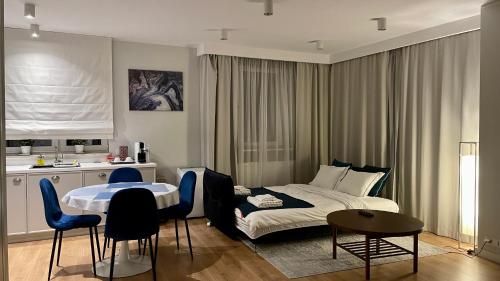 a bedroom with a bed and a table and chairs at MADOST APART MOKOTÓW 54 m2 Airport Chopin & Buisness in Warsaw