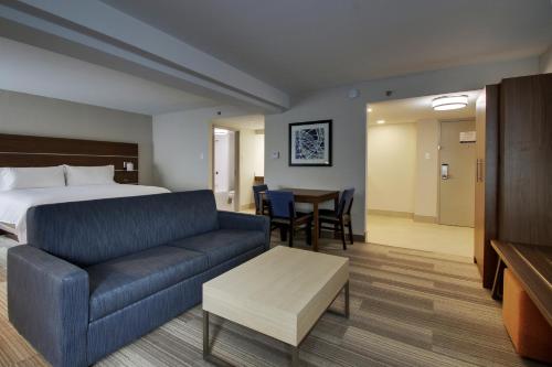 a hotel room with a bed and a couch and a table at Holiday Inn Express Voorhees/ Mt. Laurel by IHG in Voorhees