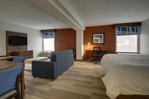 a hotel room with a bed and a chair and a desk at Holiday Inn Express Voorhees/ Mt. Laurel by IHG in Voorhees
