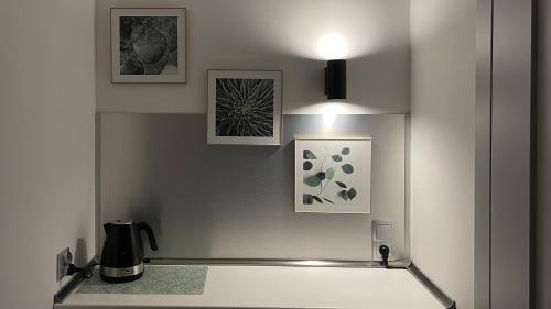 a kitchen with two pictures and a light on the wall at APARTHOTEL in Przemyśl